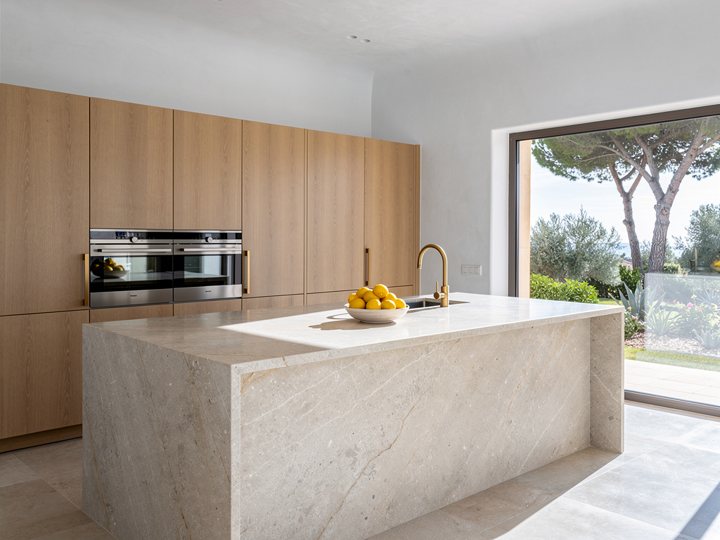 Recreación digital de cocina premium con isla de piedra natural